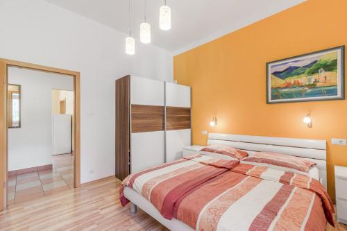 a bedroom with a bed and a orange wall at Apartma Most in Most na Soči