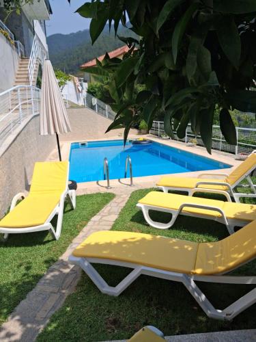 a group of yellow lounge chairs next to a swimming pool at Casa Marciana in Geres