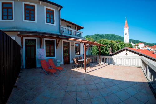 a patio with chairs and a building with a clock tower at Apartma Most in Most na Soči