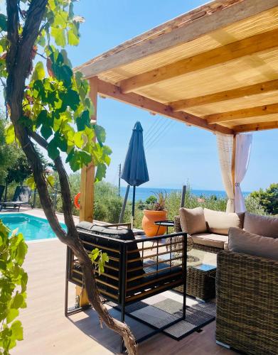 a patio with a pergola next to a pool at Sto Spiti Limani in Nea Skioni