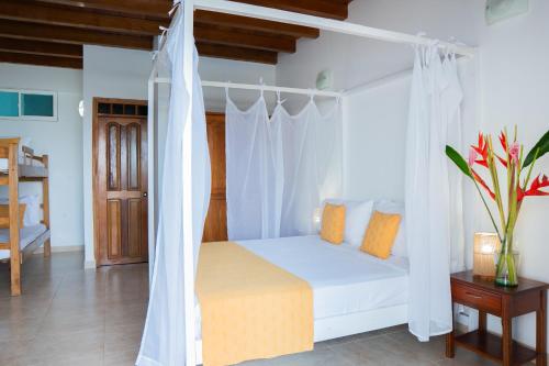 a bedroom with a white bed with a canopy at hotel 3 banderas Manzanillo del Mar in Cartagena de Indias
