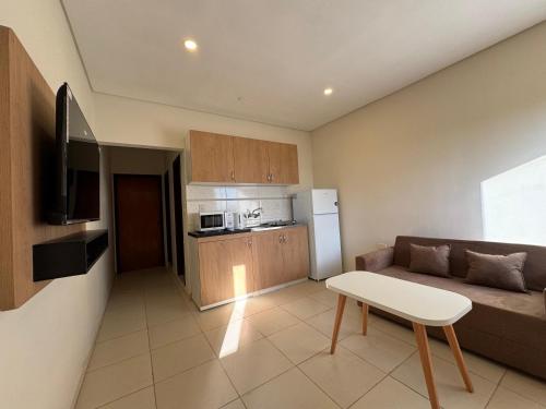 a living room with a couch and a table and a kitchen at Edificio Squef 3 in Encarnación
