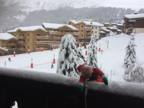 a child is laying on a ledge in the snow at Valmorel Appartement au pied des pistes in Valmorel