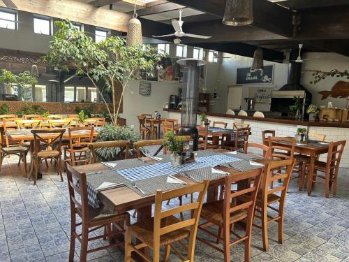 un ristorante con tavoli e sedie in legno e una cucina di Genesis Cape St Francis resort a Cape St Francis