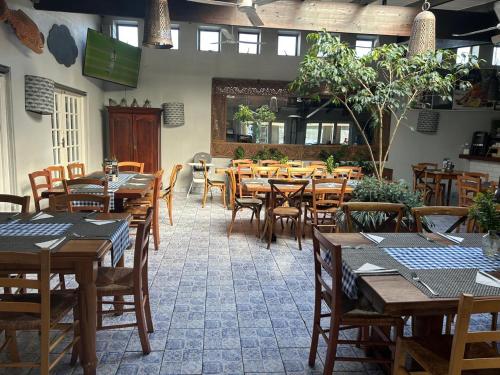 una sala da pranzo con tavoli e sedie in legno di Genesis Cape St Francis resort a Cape St Francis