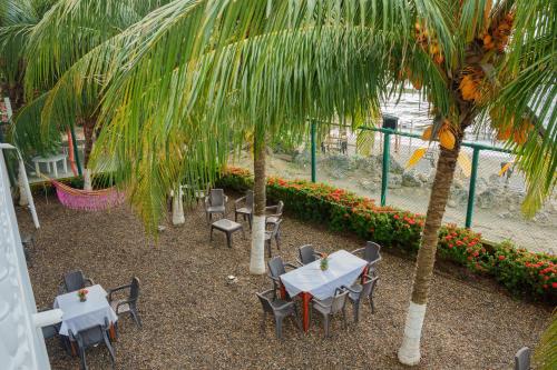 a restaurant with tables and chairs and a palm tree at hotel 3 banderas Manzanillo del Mar in Cartagena de Indias
