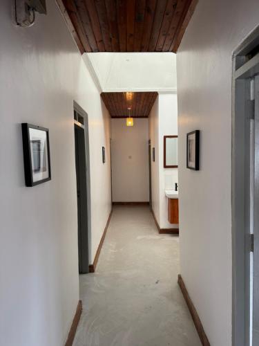 een gang met witte muren en een houten plafond bij Arusha backpackers homes in Arusha