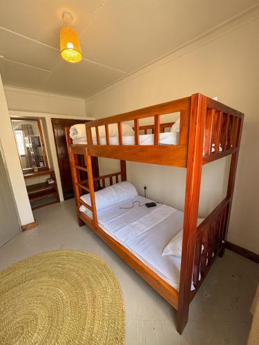 Arusha backpackers homes في أروشا: سريران بطابقين في غرفة بها سجادة