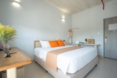 a bedroom with a large bed with orange pillows at The Up Hotel Phu Quoc Island - The Poolside Escape in Phu Quoc