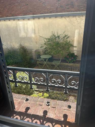 a view of a patio with a table and a tree at Le Carré Courtois in Luisant