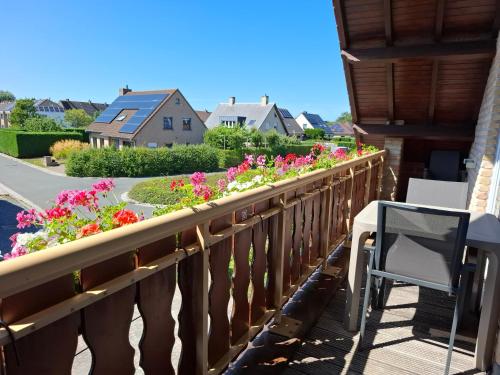 a balcony with flowers and a table and chairs at Huis Pimpernel in Bredene