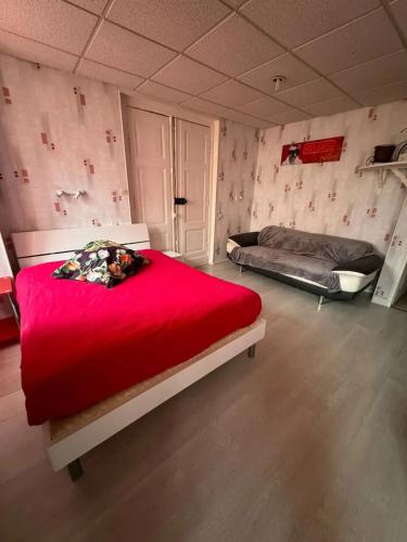 - une chambre avec 2 lits et une couverture rouge dans l'établissement Studio charmant à Néris-les-Bains - 25 m² avec terrasse, à Néris-les-Bains
