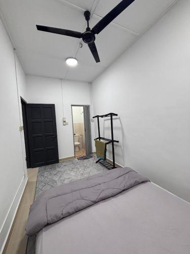 a bedroom with a bed and a ceiling fan at Inap Desa SBJ in Tumpat