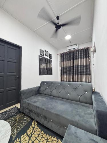 a living room with a couch and a ceiling fan at Inap Desa SBJ in Tumpat