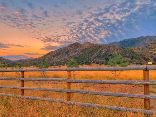 a fence in a field with mountains in the background at Rancho Grande in Ojai