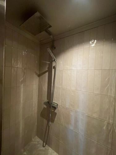 a shower in a bathroom with a tiled wall at The Nest bed and garden in Varberg