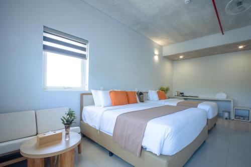 a bedroom with a large bed and a table at The Up Hotel Phu Quoc Island - The Poolside Escape in Phu Quoc