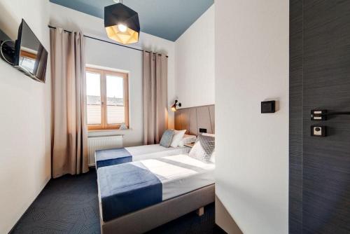 a hotel room with two beds and a window at GoldApartRooms in Białystok