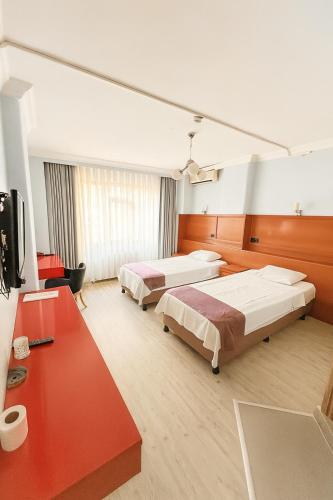 a hotel room with two beds and a television at Ferah Otel in Gebze