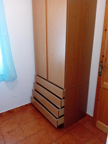 a closet with three wooden drawers next to a door at Luna e Mare in Cala Gonone