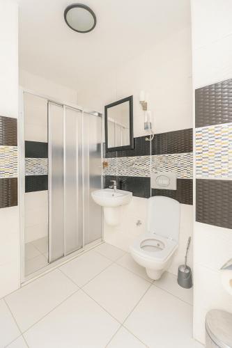 a white bathroom with a toilet and a sink at Ferah Otel in Gebze