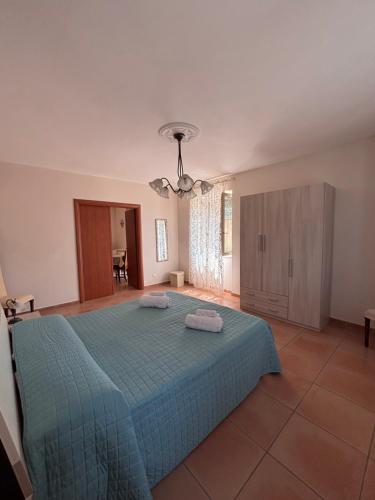 a bedroom with a blue bed with two towels on it at B&B La Terrazza in Mormanno