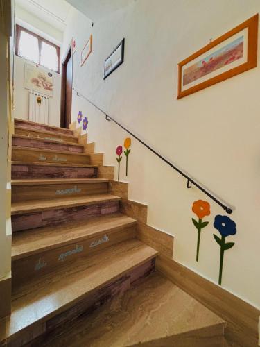 a staircase with flowers painted on the wall at "IL CASALE DEI GIRASOLI" Country House in Capalbio in Capalbio