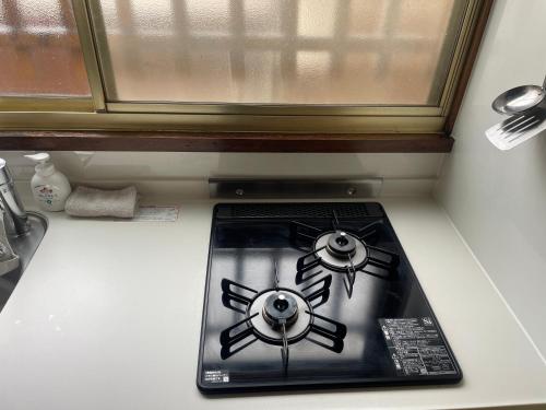 a stove top with two burners on a kitchen counter at 田辺ハウス in Kafuri