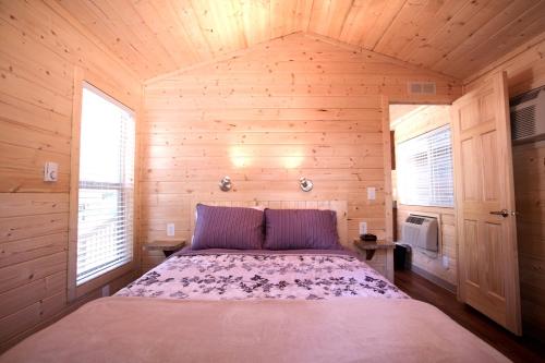 a bedroom with a bed in a wooden cabin at Soledad Canyon Cottage 5 in Ravenna