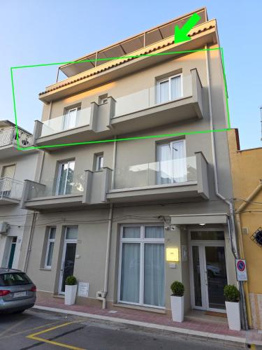 a building with a green arrow on the side of it at Light Charme, Sun Light Apartment a due passi dalla PIAZZA DUOMO in Terrasini