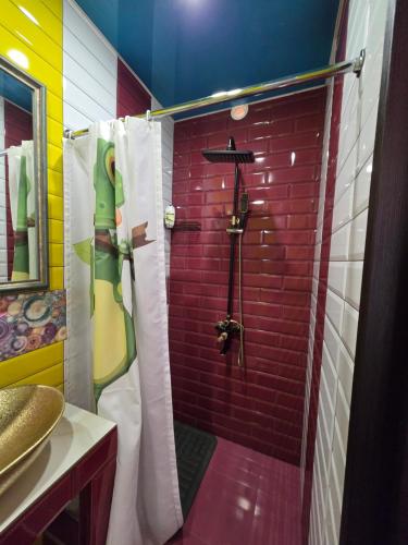 a bathroom with a shower with a red brick wall at Lada's Hotel of Sun in Yeghegnadzor