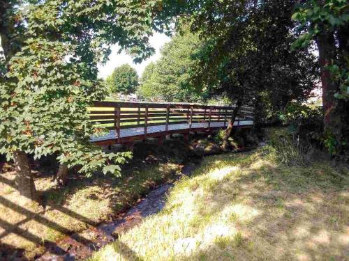 a wooden bridge in a park with trees and grass at A Casa mia in Bieno