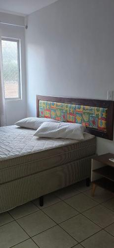 a bed with a wooden headboard in a bedroom at Rio Quente Thermas Paradise in Rio Quente
