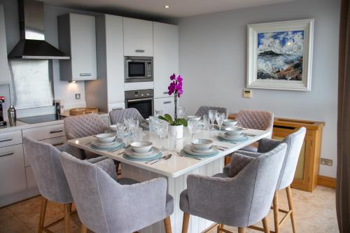a kitchen and dining room with a white table and chairs at Galway Beach Penthouse in Galway