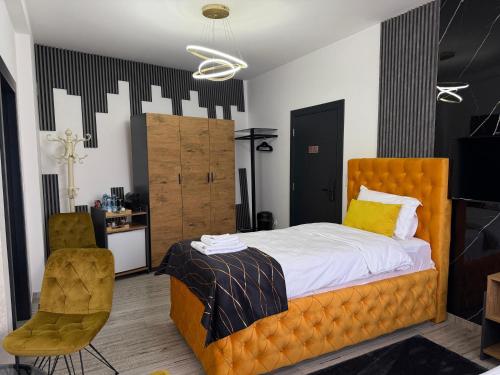 a bedroom with an orange bed and a chair at Golden Hill Palace in Novi Pazar