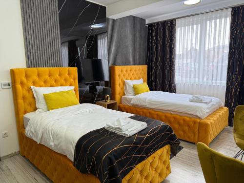 a hotel room with two beds and a television at Golden Hill Palace in Novi Pazar
