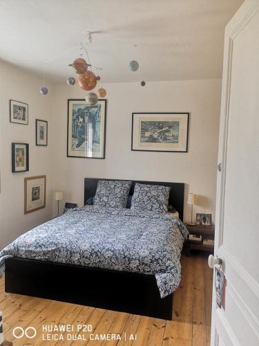 a bedroom with a bed and pictures on the wall at chambres dans Maison individuelle 46 Rue de Luzel in Saint-Brieuc