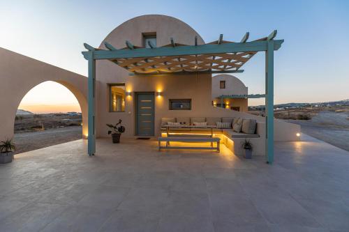 an outdoor patio with a couch and a table at Dune Santorini Villa in Vlychada