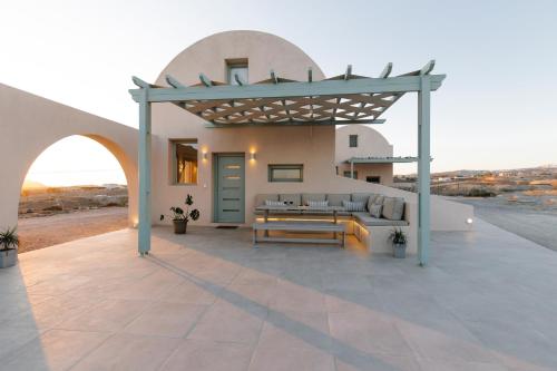 a patio of a house with a couch and a table at Dune Santorini Villa in Vlychada