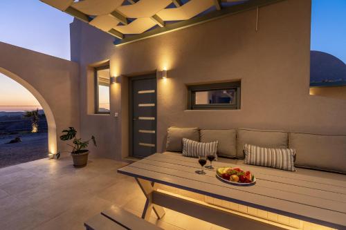 a living room with a couch and a table with a bowl of fruit at Dune Santorini Villa in Vlychada