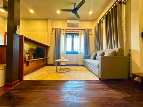 a living room with a couch and a ceiling fan at Roya Khmer Homestay in Siem Reap