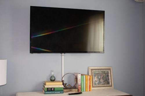 a flat screen tv hanging on a wall with books at Hartstone Inn in Camden