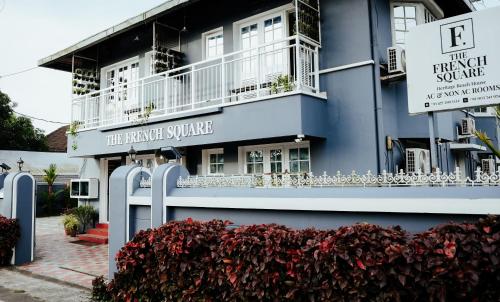 a blue building with a sign in front of it at The French Square in Alleppey