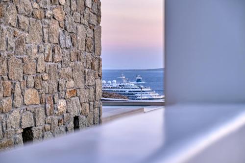 a cruise ship in the ocean viewed through a window at Paolas Sunset in Agios Stefanos