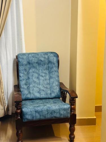 a blue chair sitting in a room next to a window at Venice villa varkala cliff -luxurious rooms and apartments in Varkala