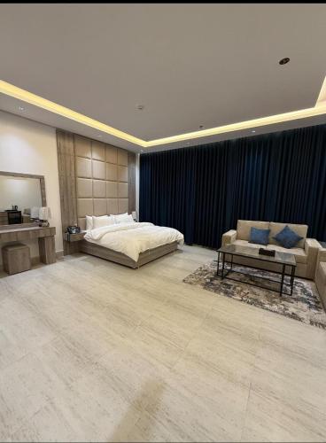 ein großes Schlafzimmer mit Bett und Sofa in der Unterkunft تاور ام للشقق المخدومه in Quai