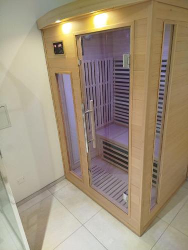 a room with a glass door to a sauna at La Grange - Maison et Parking - Portes de Chartres in Jouy