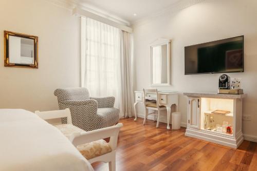 a living room with a fireplace and a tv at Hotel Boutique Santa Lucia in Cuenca