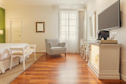 a bedroom with a bed and a table and chairs at Hotel Boutique Santa Lucia in Cuenca