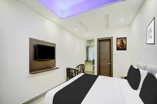 a bedroom with a bed and a tv on the wall at Super Hotel O CITY HEIGHTS in Dhanbād